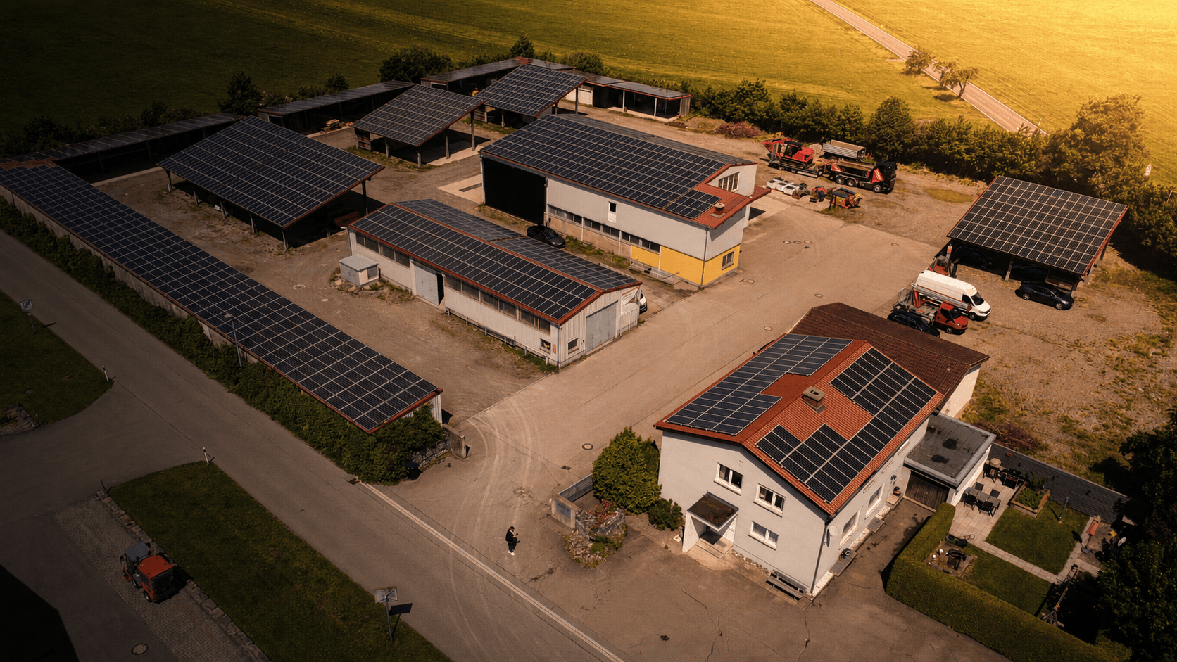 Luftaufnahme des SüdEnergie-Betriebsgeländes in Leutkirch im Allgäu mit Photovoltaikanlagen auf Dächern und Carports